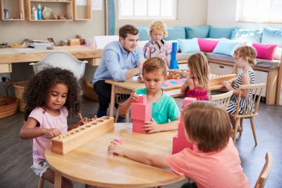 adult man and little children working at the table